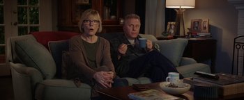 Movie still from “The Spy Who Dumped Me” (2018), directed by Susanna Fogel – A man and a woman sitting on a couch drinking coffee; Medium shot, Low angle