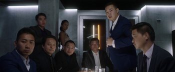 Movie still from “The Spy Who Dumped Me” (2018), directed by Susanna Fogel – A group of people sitting around a table; Medium shot, Low angle