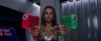 Movie still from “The Spy Who Dumped Me” (2018), directed by Susanna Fogel – A woman in a sequined dress holding two red and green toy guns; Close Up shot, Overhead angle