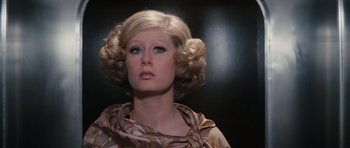 Movie still from “The Spy Who Loved Me” (1977), directed by Lewis Gilbert – A woman in a brown and white dress looking to her left; Close Up shot, Low angle