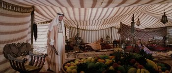 Movie still from “The Spy Who Loved Me” (1977), directed by Lewis Gilbert – A man standing in front of a bed of fruit; Wide shot, High angle