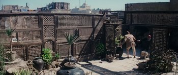Movie still from “The Spy Who Loved Me” (1977), directed by Lewis Gilbert – An outdoor area with a wooden fence and potted plants; Wide shot, High angle