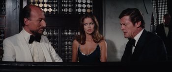 Movie still from “The Spy Who Loved Me” (1977), directed by Lewis Gilbert – A woman sitting in front of two other people; Medium shot, Over the shoulder angle