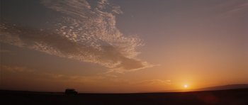 Movie still from “The Spy Who Loved Me” (1977), directed by Lewis Gilbert – A truck is parked in the middle of a field at sunset; Extreme Wide shot, Low angle