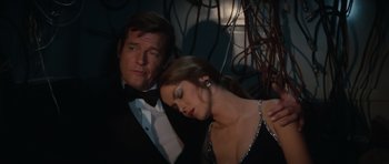 Movie still from “The Spy Who Loved Me” (1977), directed by Lewis Gilbert – A man and a woman in formal wear posing for a picture; Medium shot, High angle