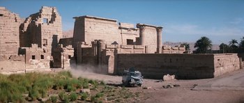 Movie still from “The Spy Who Loved Me” (1977), directed by Lewis Gilbert – An old truck is driving past an ancient building; Extreme Wide shot, Low angle