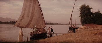 Movie still from “The Spy Who Loved Me” (1977), directed by Lewis Gilbert – A group of men standing on a pier next to a boat; Extreme Wide shot, High angle