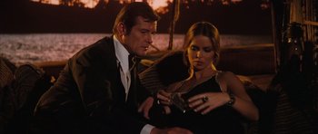 Movie still from “The Spy Who Loved Me” (1977), directed by Lewis Gilbert – A man and a woman looking at a cell phone; Medium shot, Over the shoulder angle