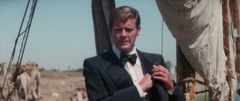 Movie still from “The Spy Who Loved Me” (1977), directed by Lewis Gilbert – A man in a tuxedo adjusting his bow tie; Medium shot, Low angle