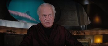 Movie still from “The Spy Who Loved Me” (1977), directed by Lewis Gilbert – An older man in a black shirt is looking at the camera; Close Up shot, Low angle