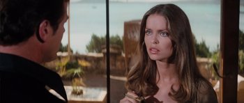 Movie still from “The Spy Who Loved Me” (1977), directed by Lewis Gilbert – A beautiful woman with long brown hair and blue eyes holding a pen; Close Up shot, Over the shoulder angle