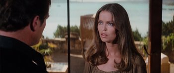 Movie still from “The Spy Who Loved Me” (1977), directed by Lewis Gilbert – A beautiful woman with long brown hair standing in front of a window; Close Up shot, Over the shoulder angle