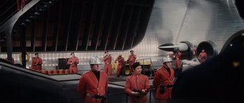 Movie still from “The Spy Who Loved Me” (1977), directed by Lewis Gilbert – A group of men in red suits standing next to each other; Extreme Wide shot, Low angle