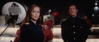 Movie still from “The Spy Who Loved Me” (1977), directed by Lewis Gilbert – A woman in a uniform standing next to a man in a uniform; Medium shot, Low angle