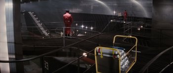 Movie still from “The Spy Who Loved Me” (1977), directed by Lewis Gilbert – A man in a red jacket standing in a stadium; Extreme Wide shot, High angle