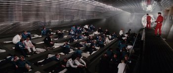 Movie still from “The Spy Who Loved Me” (1977), directed by Lewis Gilbert – A group of people sitting in rows of seats; Extreme Wide shot, High angle