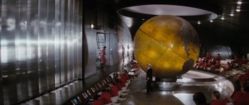 Movie still from “The Spy Who Loved Me” (1977), directed by Lewis Gilbert – A group of people standing in front of a large globe; Extreme Wide shot, High angle