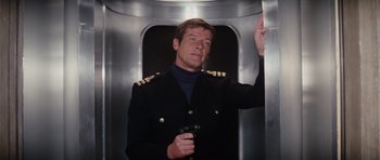 Movie still from “The Spy Who Loved Me” (1977), directed by Lewis Gilbert – A man in a black jacket holding a gun; Medium shot, Low angle