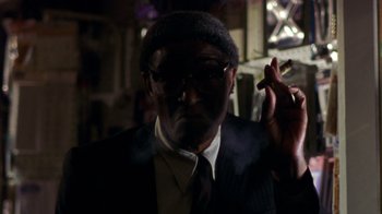 Movie still from “The Station Agent” (2003), directed by Tom McCarthy – A man in a suit and tie smoking a cigarette; Close Up shot, Low angle