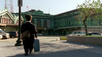 Movie still from “The Station Agent” (2003), directed by Tom McCarthy – A man walking down a street holding a suitcase; Extreme Wide shot, Low angle