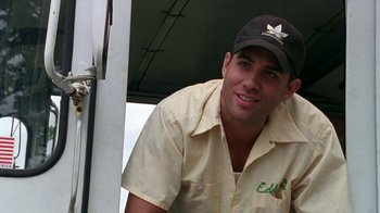 Movie still from “The Station Agent” (2003), directed by Tom McCarthy – A man wearing a hat and smiling for the camera; Close Up shot, Low angle