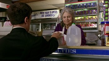 Movie still from “The Station Agent” (2003), directed by Tom McCarthy – A man is handing a woman a bag of food at a sandwich shop; Medium shot, Over the shoulder angle