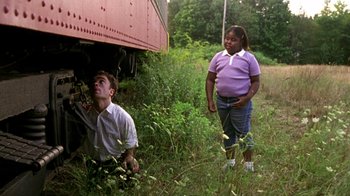 Movie still from “The Station Agent” (2003), directed by Tom McCarthy – A man and a woman standing next to a train; Medium shot, Low angle