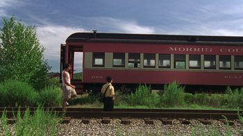 Movie still from “The Station Agent” (2003), directed by Tom McCarthy – Two people standing on a train track next to a train car; Wide shot, Low angle