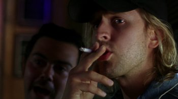 Movie still from “The Station Agent” (2003), directed by Tom McCarthy – A man smoking a cigarette while another man looks on; Close Up shot, Low angle