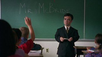 Movie still from “The Station Agent” (2003), directed by Tom McCarthy – A man standing in front of a chalkboard in front of a boy; Medium shot, Over the shoulder angle