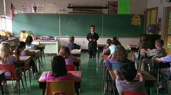 Movie still from “The Station Agent” (2003), directed by Tom McCarthy – A man standing in front of a class room; Wide shot, High angle