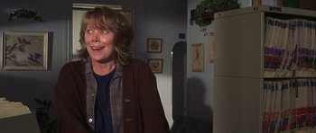 Movie still from “The Straight Story” (1999), directed by David Lynch – A woman standing in a room with a smile on her face; Medium shot, Low angle