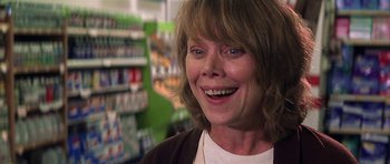 Movie still from “The Straight Story” (1999), directed by David Lynch – An older woman smiling for the camera in a store; Close Up shot, Low angle