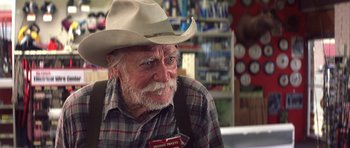 Movie still from “The Straight Story” (1999), directed by David Lynch – An older man wearing a cowboy hat and a plaid shirt; Close Up shot, Over the shoulder angle