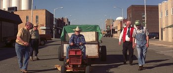 Movie still from “The Straight Story” (1999), directed by David Lynch – An older man sitting on top of a lawn mower; Wide shot, High angle
