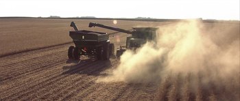 Movie still from “The Straight Story” (1999), directed by David Lynch – A couple of trucks that are in the dirt; Extreme Wide shot, High angle