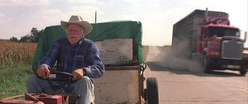 Movie still from “The Straight Story” (1999), directed by David Lynch – An old man riding in the back of a horse drawn carriage; Wide shot, Low angle