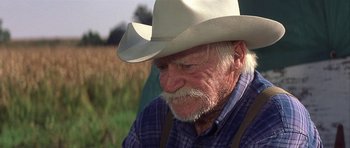 Movie still from “The Straight Story” (1999), directed by David Lynch – An older man wearing a white cowboy hat; Close Up shot, Over the shoulder angle