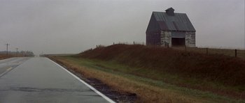 Movie still from “The Straight Story” (1999), directed by David Lynch – An old barn sitting on top of a grass covered hill; Extreme Wide shot, Low angle