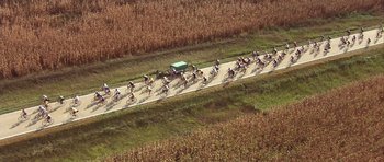 Movie still from “The Straight Story” (1999), directed by David Lynch – A group of bicyclists riding down a dirt road; Extreme Wide shot, High angle