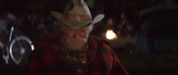 Movie still from “The Straight Story” (1999), directed by David Lynch – An older man wearing a cowboy hat and a plaid shirt; Close Up shot, Over the shoulder angle