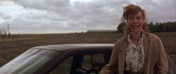 Movie still from “The Straight Story” (1999), directed by David Lynch – A woman standing in the back of a car in a field; Medium shot, Over the shoulder angle