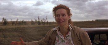 Movie still from “The Straight Story” (1999), directed by David Lynch – A woman in a floral shirt is standing in a field; Close Up shot, Low angle