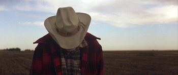 Movie still from “The Straight Story” (1999), directed by David Lynch – A man wearing a cowboy hat in a field; Close Up shot, Low angle