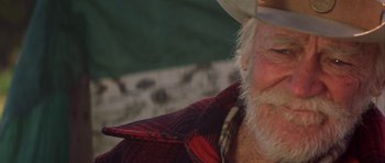 Movie still from “The Straight Story” (1999), directed by David Lynch – An old man with a beard wearing a cowboy hat; Close Up shot, Low angle