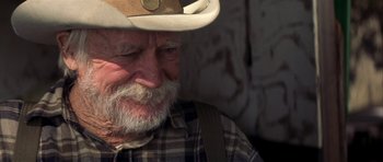 Movie still from “The Straight Story” (1999), directed by David Lynch – An old man with a beard wearing a cowboy hat; Close Up shot, Over the shoulder angle