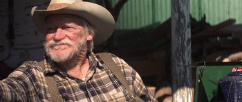 Movie still from “The Straight Story” (1999), directed by David Lynch – An older man wearing a hat and a plaid shirt; Close Up shot, Over the shoulder angle