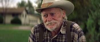 Movie still from “The Straight Story” (1999), directed by David Lynch – An old man with a gray beard wearing a cowboy hat; Close Up shot, Over the shoulder angle