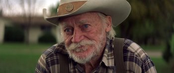 Movie still from “The Straight Story” (1999), directed by David Lynch – An old man with a white beard wearing a cowboy hat; Close Up shot, Over the shoulder angle