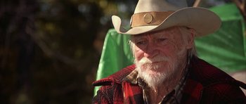 Movie still from “The Straight Story” (1999), directed by David Lynch – An old man with a white beard wearing a cowboy hat; Close Up shot, Over the shoulder angle